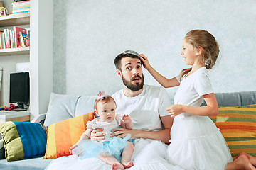 Image showing The happy father and his baby daughters at home