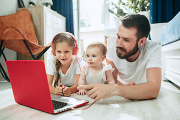 Image showing father and his daughters at home