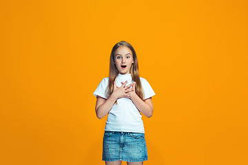 Image showing Beautiful teen girl looking suprised isolated on orange