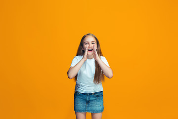 Image showing Isolated on yellow young casual teen girl shouting at studio