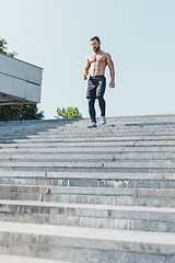 Image showing Fit man doing exercises outdoors at city