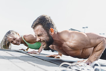 Image showing Fit fitness woman and man doing fitness exercises outdoors at city