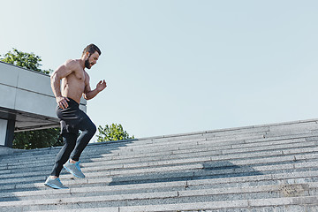 Image showing Fit man doing exercises outdoors at city