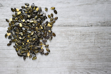 Image showing pumpkeen seeds scattered over white stone board