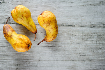 Image showing yellow pears on white wooden background, top view.