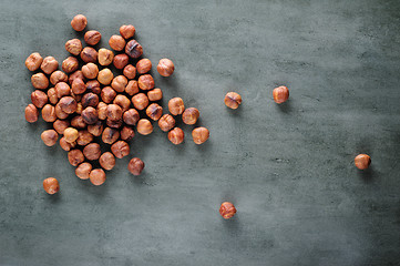 Image showing Peeled hazelnuts scattered over stone board