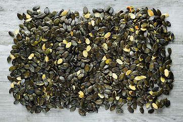 Image showing pumpkeen seeds scattered over stone board