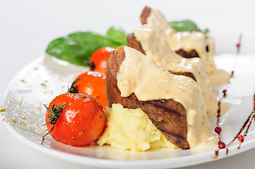 Image showing Baked mutton meat with creamy sauce, mashed potato and cherry tomatoes