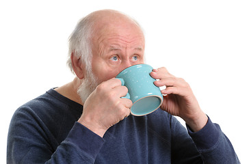 Image showing Elderly man drinking from mug, isolated on white