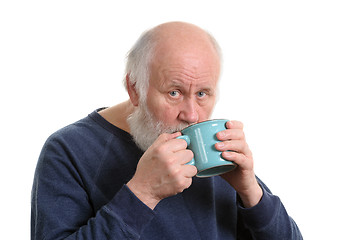 Image showing Elderly man drinking from mug, isolated on white