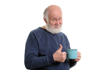 Image showing elderly man with cup of bad tea or coffee showing thumb up isolated on white