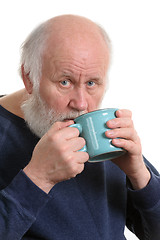 Image showing Elderly man drinking from mug, isolated on white