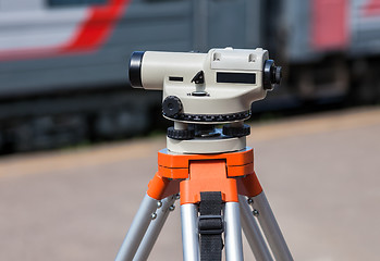 Image showing Geodetic equipment optical level mounted on tripod at the railwa