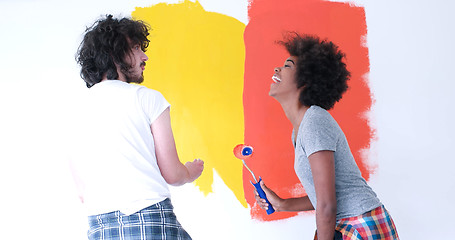 Image showing multiethnic couple painting interior wall