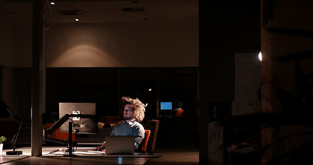 Image showing man working on computer in dark office