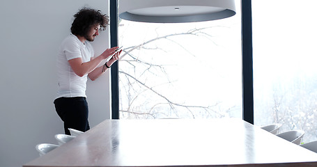 Image showing young man using a tablet at home