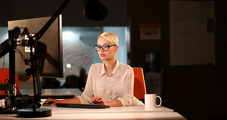 Image showing woman working on computer in dark office