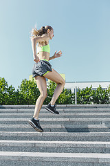 Image showing Pretty sporty woman jogging at park in sunrise light