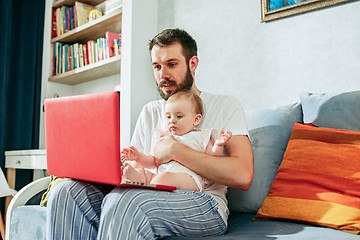 Image showing Proud father holding his baby daughtesr at home