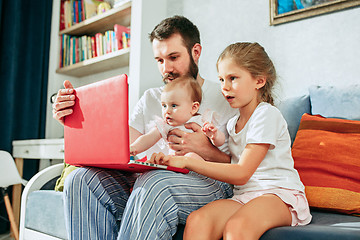 Image showing father and his daughters at home