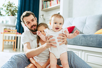 Image showing Proud father holding his newborn baby daughter at home