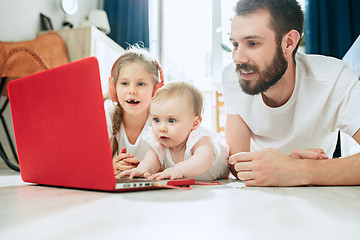 Image showing father and his daughters at home