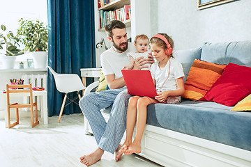 Image showing father and his daughters at home