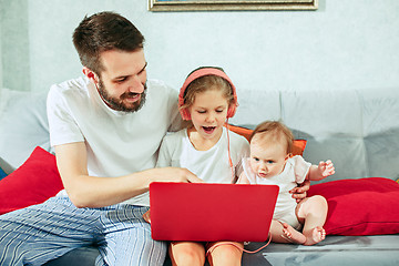 Image showing father and his daughters at home