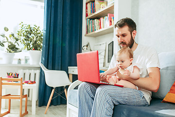 Image showing Proud father holding his baby daughtesr at home