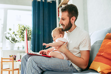 Image showing Proud father holding his baby daughtesr at home