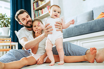 Image showing Proud father holding his newborn baby daughter at home