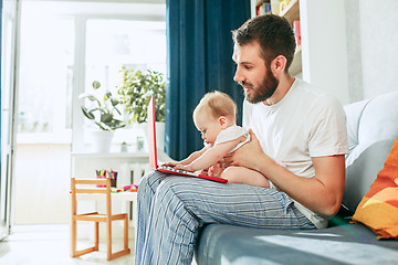 Image showing Proud father holding his baby daughtesr at home