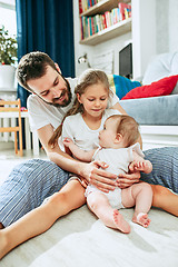 Image showing Proud father holding his newborn baby daughter at home