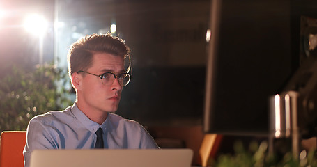 Image showing man working on computer in dark office