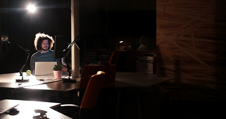 Image showing man working on computer in dark office