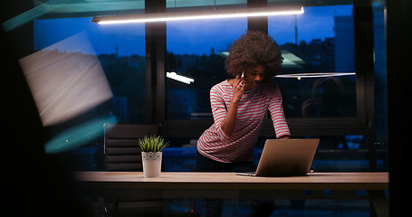 Image showing black businesswoman using a laptop in night startup office