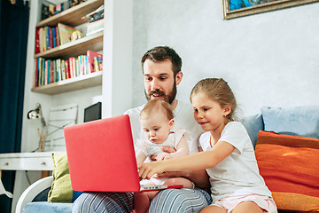 Image showing father and his daughters at home