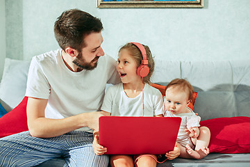 Image showing father and his daughters at home