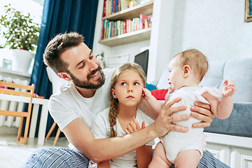 Image showing Proud father holding his newborn baby daughter at home