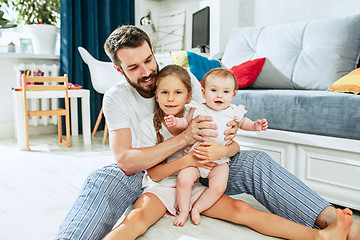 Image showing Proud father holding his newborn baby daughter at home