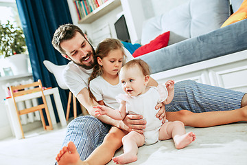 Image showing Proud father holding his newborn baby daughter at home