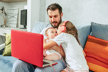 Image showing father and his daughters at home