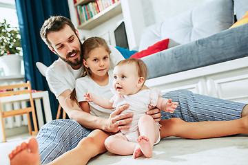 Image showing Proud father holding his newborn baby daughter at home