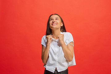 Image showing The happy business woman standing and smiling against red background.