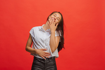 Image showing The happy business woman standing and smiling against red background.