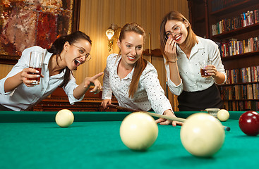 Image showing Young women playing billiards at office after work.