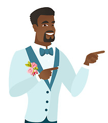 Image showing Young african-american groom pointing to the side.