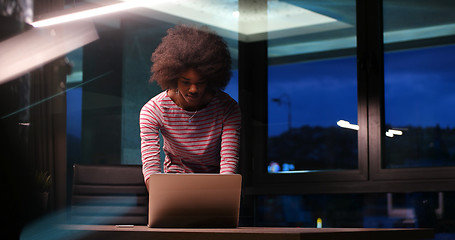 Image showing black businesswoman using a laptop in night startup office