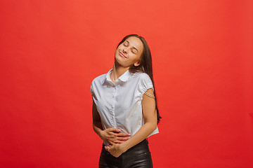 Image showing The happy business woman standing and smiling against red background.