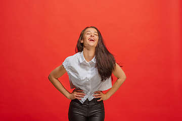 Image showing The happy business woman standing and smiling against red background.